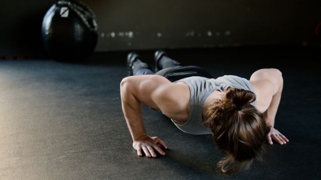 Woman at the bottom range of a press up, just before the lifting phase