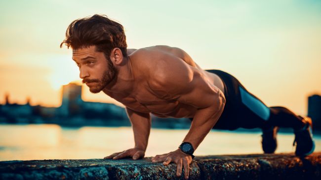 Topless man performing a narrow grip push up to place more emphasis on the triceps and other arm muscles